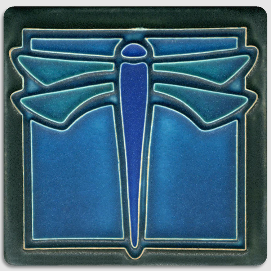 Decorative tile with a blue dragonfly design on a dark green background