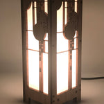 A mini lightbox lamp with geometric art glass window designs, made of cherry veneered MDF and shoji paper, with an illuminated candelabra base.