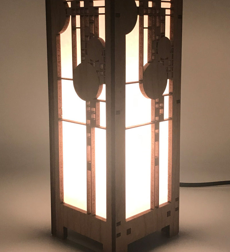 A mini lightbox lamp with geometric art glass window designs, made of cherry veneered MDF and shoji paper, with an illuminated candelabra base.