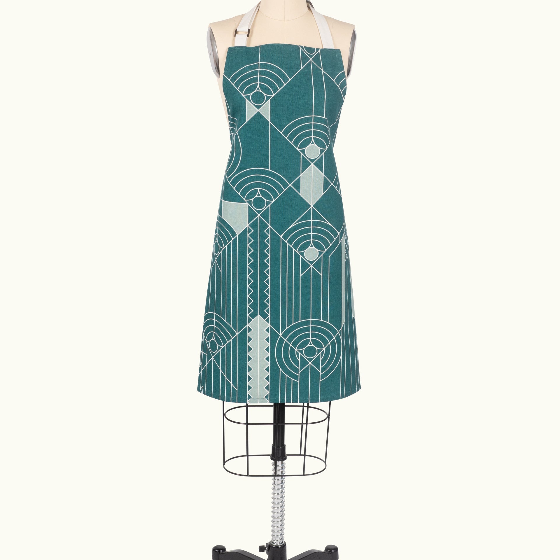 A blue apron with geometric patterns displayed on a mannequin.