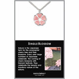 A silver-colored chain necklace with a pendant in the shape of a cherry blossom, displayed on a black card with a smaller image of cherry blossoms and text.