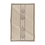 A beige and black jacquard tea towel with a geometric arrow design, laid flat.