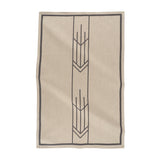 A beige and black jacquard tea towel with a geometric arrow design, laid flat.
