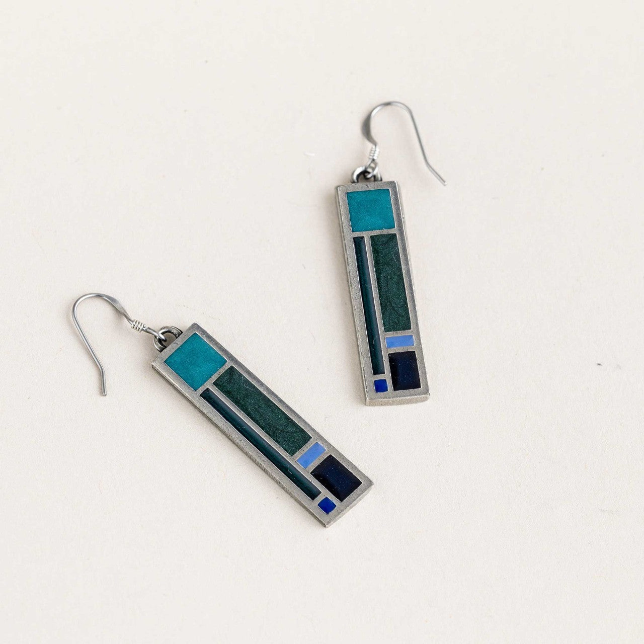 A pair of pewter earrings with blue and green accents