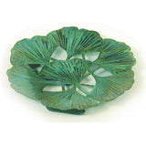 A decorative brass plate with a patina finish featuring a ginkgo leaf design, approximately 4.25 inches round.