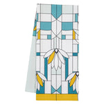 A folded 100% cotton tea towel with a geometric and floral design in white, blue, and yellow.