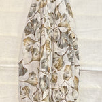 Floral patterned scarf draped over a gold rod on a white background
