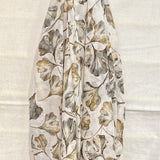 Floral patterned scarf draped over a gold rod on a white background