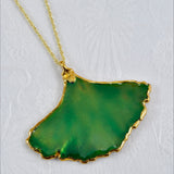 A necklace featuring a real Ginkgo Leaf shaped pendulum with a gold and lacquered green finish, attached to an 18-inch gold chain.